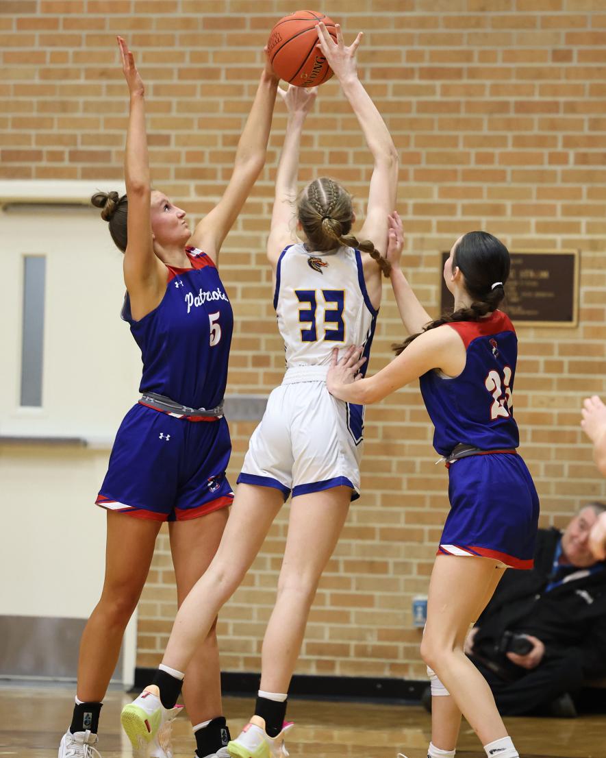 Senior Lanae Elbers (No. 5) and junior Emma Deelstra (No. 23) guard the net against Adrian during their section quarterfinal game Saturday, Feb. 24, in Worthington. The Patriots beat the Dragons 64-61 in the overtime game.