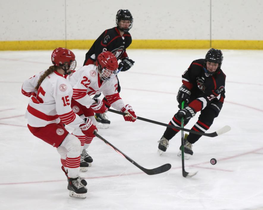 Greg Hoogeveen photos/1228 GHOC W1 Freshman Rylee Kurtz, No. 22, and sophomore Greta McClure, No. 15, defend Luverne’s net against a Worthington attack Thursday, Dec. 21, in Luverne. LHS defeated the Trojans 10-1 in the game.