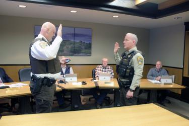 Rock County Sheriff Evan Verbrugge (left) administers the service oath to the newest deputy sheriff, Troy Wenzel, at the Dec. 26 Rock County Board meeting. Commissioners pictured are (from left) Greg Burger, Gary Overgaard, Stan Williamson (hidden) and Jody Reisch. Mavis Fodness/Rock County Star Herald Photo