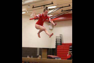 LHS junior Kendra Thorson leaps above the beam to perform one of the required skills in her routine. The Cardinals beat Redwood Valley 130.825 to 130.700 in the team competition. Thorson scored a 7.3500 on the beam.