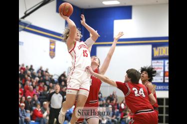 LHS senior Gavin DeBeer leaps over several Redwood Valley players to collect two points in the Section 3AA quarterfinal game in Windom. Luverne fell to Redwood 93-66 to end their season 12-13.