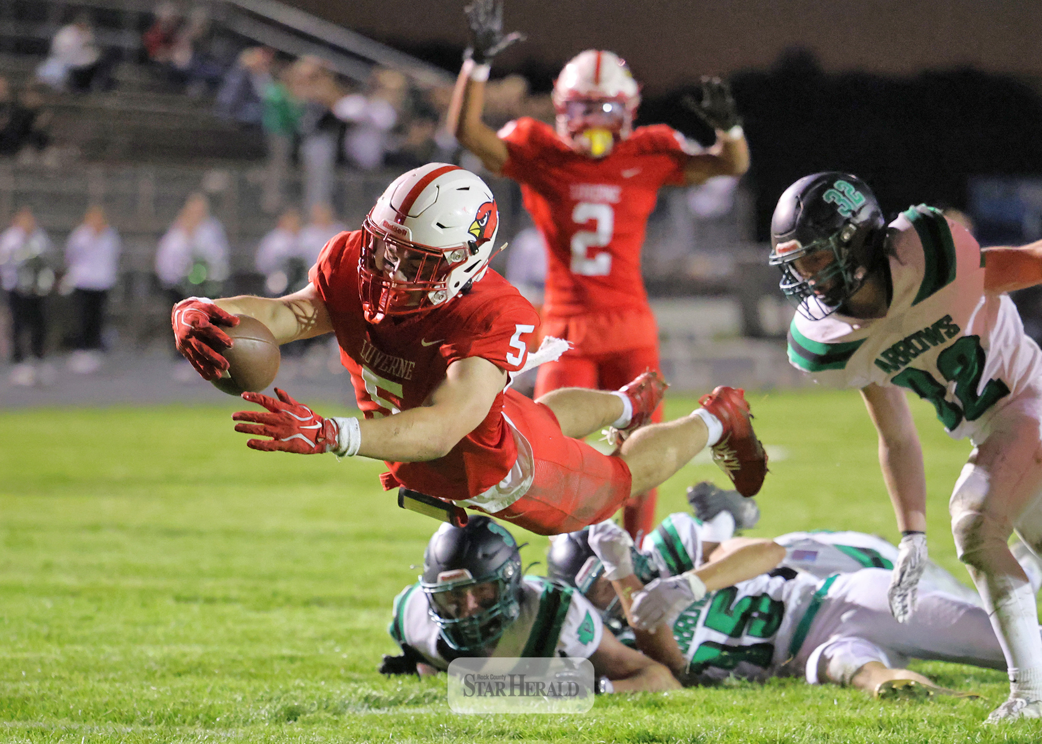 Greg Hoogeveen photo/1008LHSFB1 Cardinals senior Matthew Gangestad leaps into the end zone after breaking through three Pipestone players at the 3-yard line for a LHS touchdown. Luverne beat Pipestone 42-0 Friday, Oct. 2, at home in the annual Battle Axe contest.