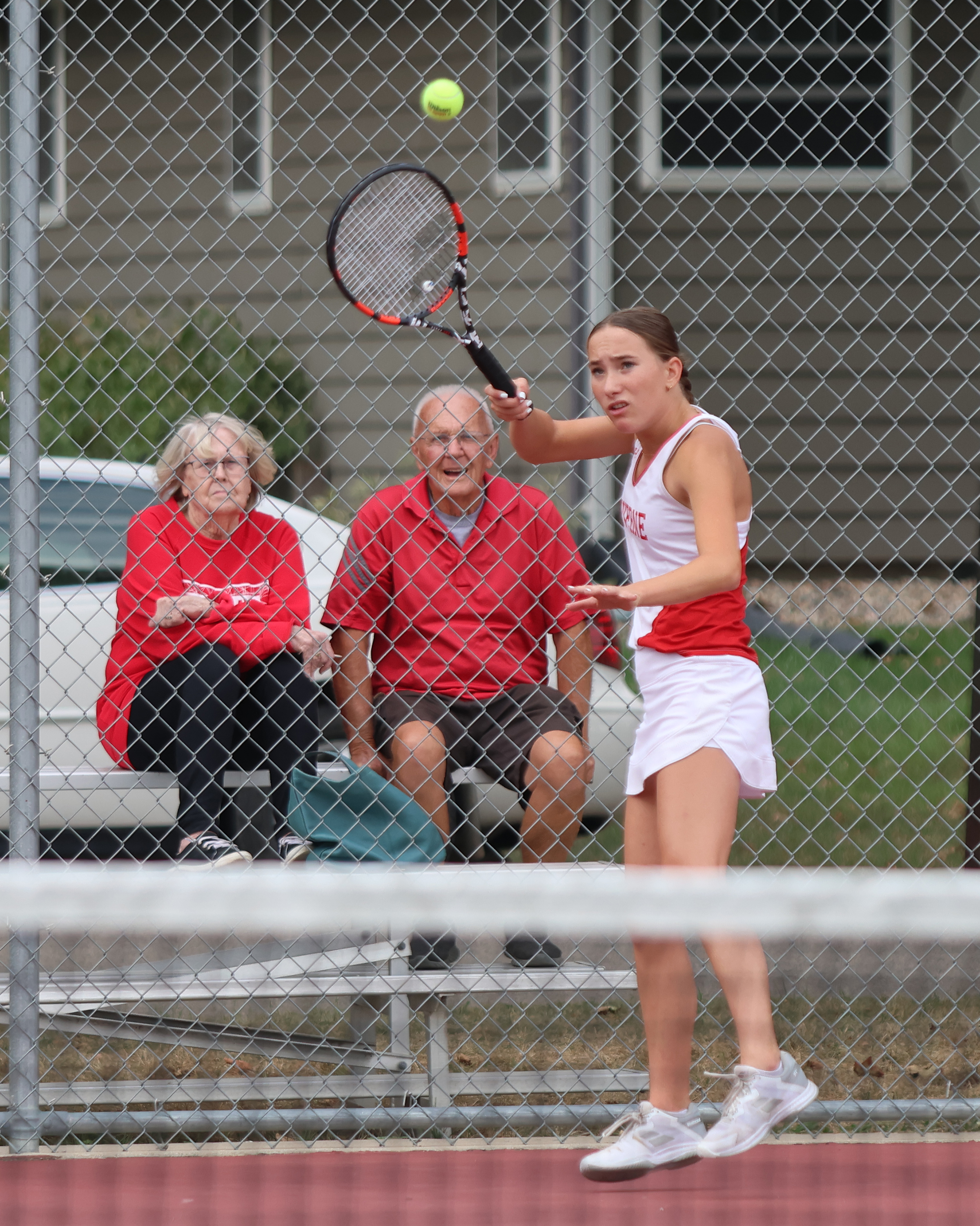Senior Morgan Hadler returns a volley against her Marshall opponents Thursday, Sept. 7, at the Luverne tennis courts. Her grandparents, Ray and Joann Hoogeveen, sit in the stands behind her watching intently.