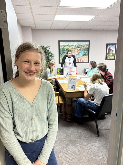 Taedra McKenzie taps her dad, Casey McKenzie (standing in background) to lead the Dungeons and Dragons game during the Board Game Day event she organized earlier this month. Submitted Photo
