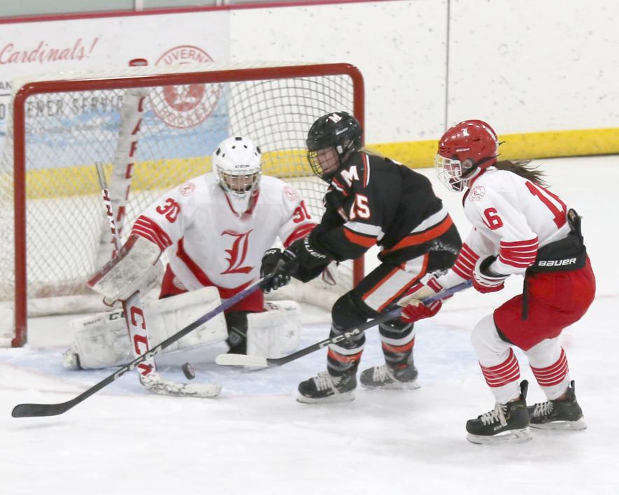 Sophomore Luverne goalie Emma Saarloos, No. 30, blocks a Marshall shot as freshman Macie Edstrom, No. 16, looks to knock the puck away from the front of the goal. Marshall beat Luverne 5-2 Thursday, Jan. 25, in Luverne.