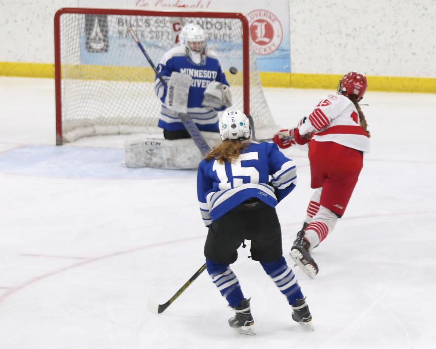 LHS sophomore Grete McClure sends the puck past the Minnesota River goalie in the first period making the game LHS 3, Bulldogs 1. The Cardinals won the game 6-2 at home Saturday, Feb. 3.