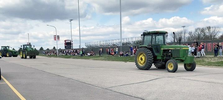 Aubrey Van Belle (right) leads the tractor parade Friday afternoon followed by Maren Stegenga and Landon Ahrendt as students from Luverne Elementary wave to the FFA members. Shared Image