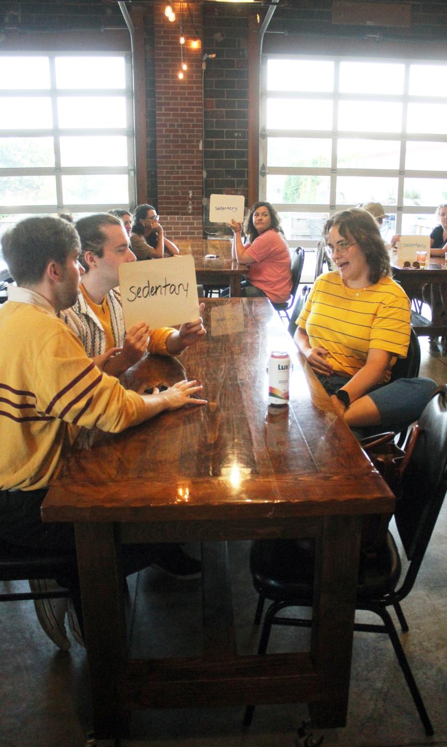The team of Andrew Prekker (left), Evan Prekker and Anita Marden decide the spelling of “sedentary” during the Adult Spelling Bee July 30 sponsored by the Rock County Library at Take 16 in Luverne. The team of Leah Ayom, Amber Decker and Amelia Brake is in the background. Mavis Fodness/Rock County Star Herald Photo