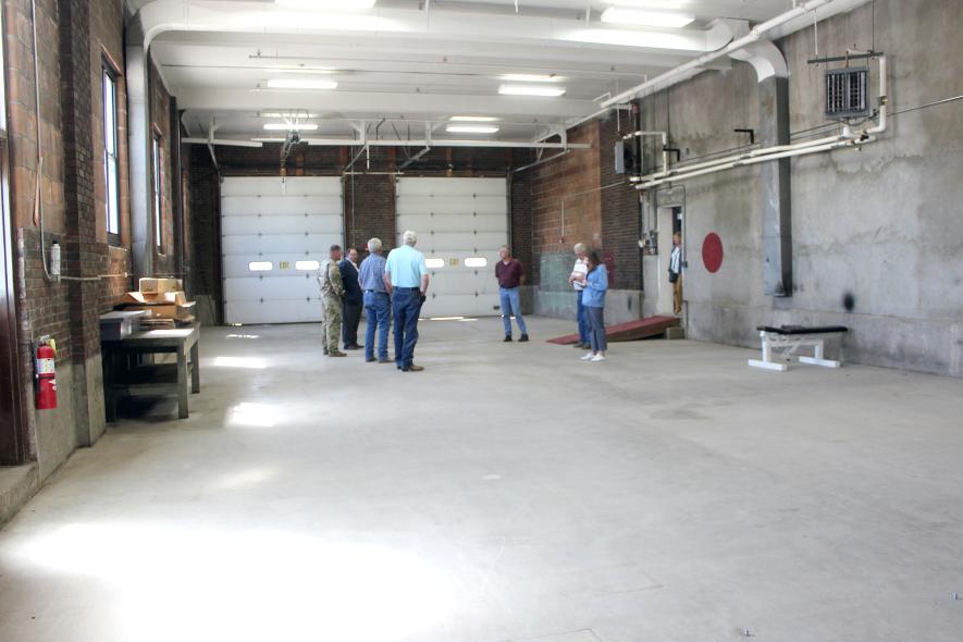 Minnesota National Guard Readiness Center officers lead Rock County commissioners, county staff and members of the press on a tour of the former armory in Luverne Tuesday, Aug. 6. Above, the group views the former garage area of the armory. Mavis Fodness/Rock County Star Herald Photo
