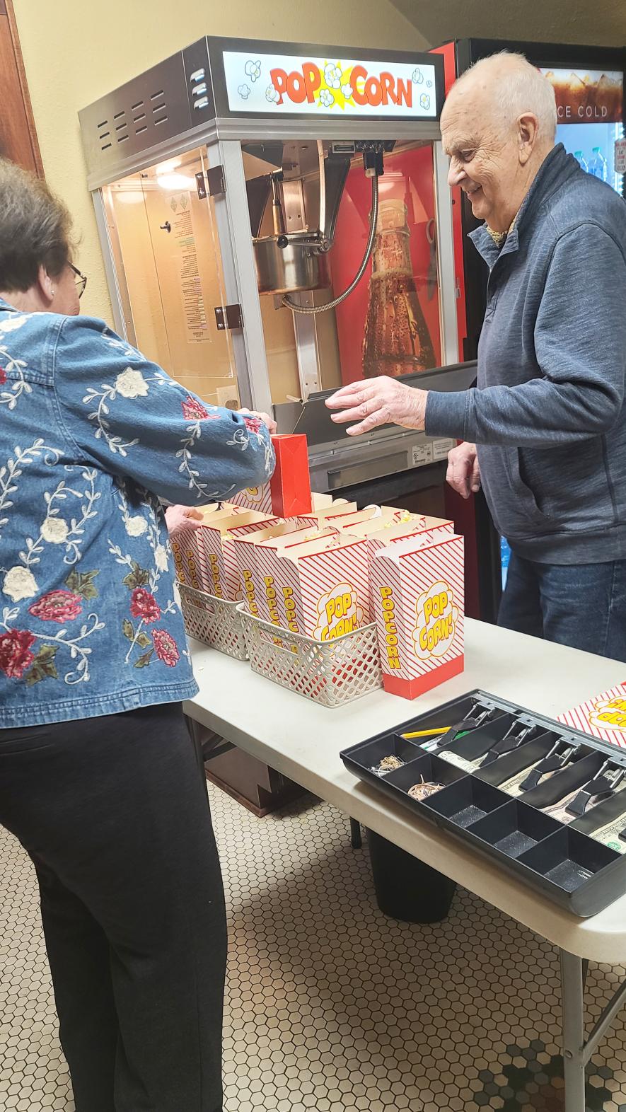 Blue Mound Area Theatre volunteers Karen Buss (left) and Charlie Berzins make and box up popcorn at a recent event at the Palace Theatre. BMAT volunteers served 12,159 people in 2022, according to a recent volunteer report. Contributed Photo
