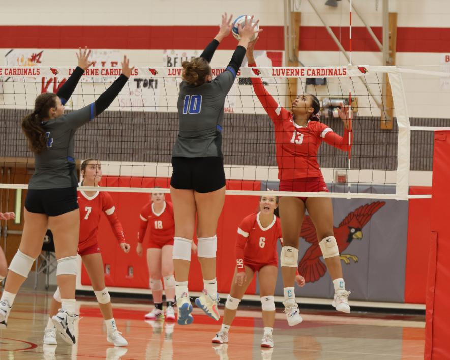 Senior Kira John jumps to spike the ball past two West Lyon blockers Thursday, Aug. 31, at the Luverne Triangular. Luverne beat West Lyon 25-22 and 26-24 and defeated Murray County Central 25-21 and 25-21 in an earlier match.