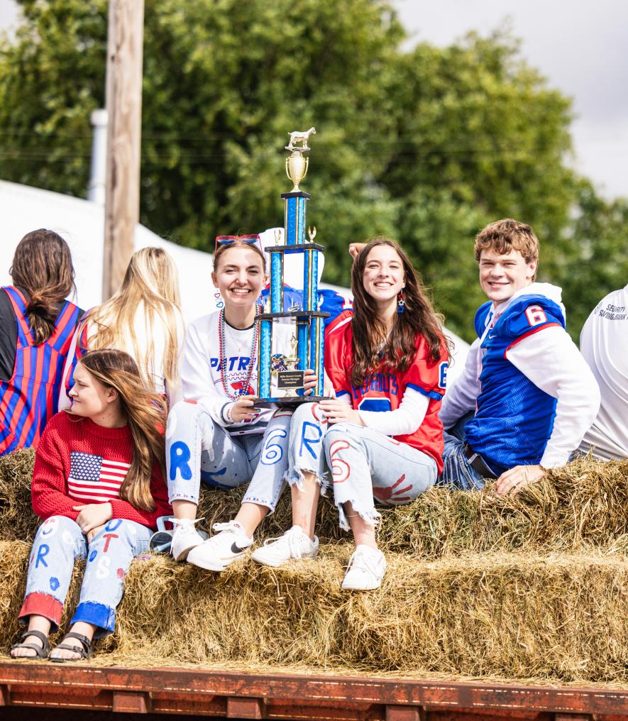 Holding the “Hills-Beaver Creek Patriots Olympic Trophy” are Abby Olson (left) and Mya Erickson. Jamin Metzger sits far right. The seniors won the trophy competing in various events prior to the parade. Samantha McGaffee/Rock County Star Herald photo
