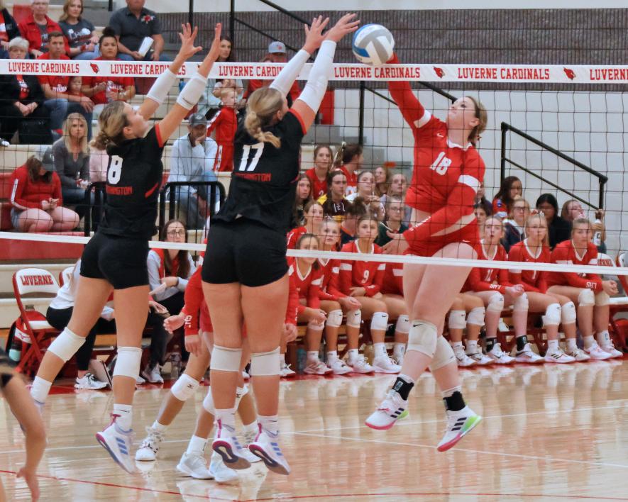 Senior Morgan Ahrendt spikes the ball through two Worthington middle blockers in Luverne. The Cardinals beat the Worthington Trojans 3-2 Tuesday, Sept. 26.
