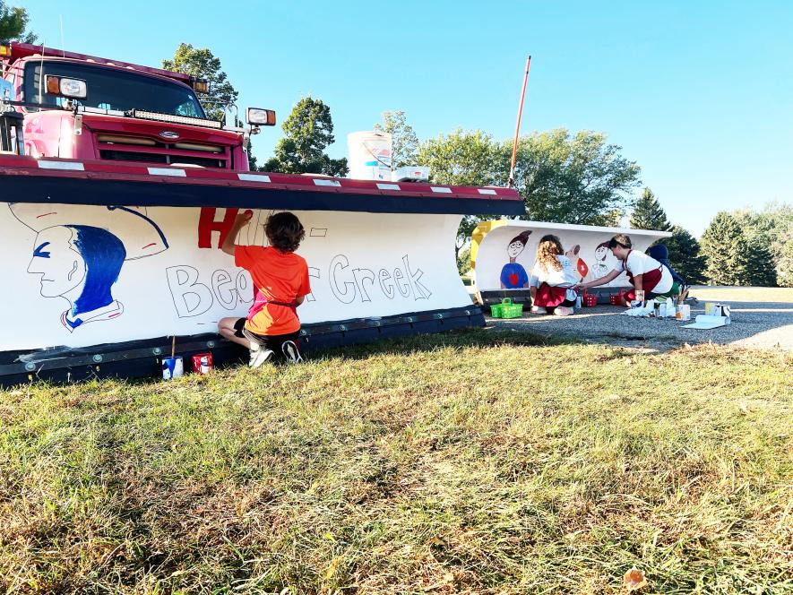 Ryder Klosterbuer (left), Vivi Tatge and Jonah Gogue take their turns painting designs on the city of Beaver Creek snowplow blades. Contributed photo