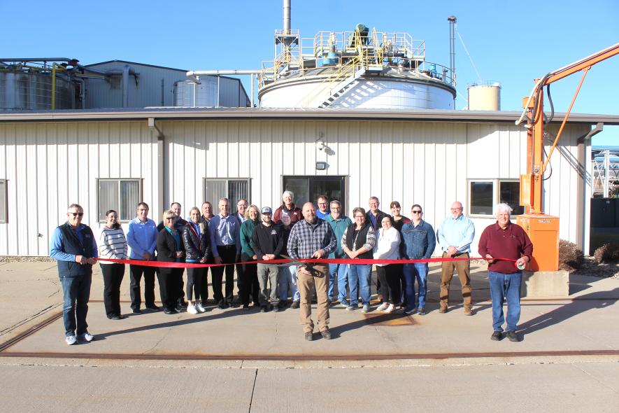 Pictured holding the ribbon are (from left) Luverne Mayor Pat Baustian, plant manager Mike Stanley and Agri-Energy co-founder David Kolsrud. In back are (from left) Chamber Director Kenzi Klein, James Vanden Brink, Annie Opitz, Wyatt VanSteenberg, Amber Brockberg, Brian Pfarr, Paul Vandeberg, County Administrator Kyle Oldre, Cris Oeltjenbruns, Matthew Sterrett, Becky Walgrave, Richard Morgan, Michael Blank, Maryln Van Grootheest, Dan Heard, Brittany Fahrenholtz, Ryann Beukema, Dave Vis and Bill Paulsen.
