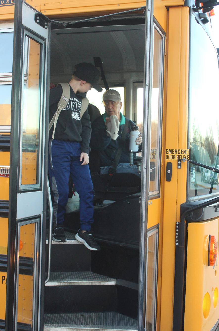 Sam Hansen asks third-grader Vance Dressen if the stocking cap and/or water bottle Hansen found on the bus was his items. Hansen has been behind the wheel (and getting forgotten items back to students) for 60 years. Mavis Fodness/Rock County Star Herald Photo