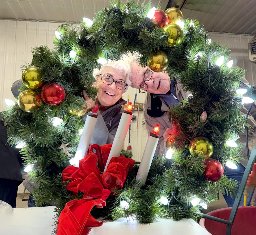  Shirley and Lowell Harrison smile through a newly lighted Christmas wreath that they replaced bulbs on. Lori Sorenson/Rock County Star Herald Photo