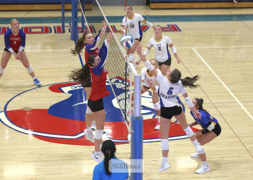Greg Hoogeveen photo/1008HBCAEVB2 A-E junior Jordan Kruger reaches for a ball at the net as H-BC players junior Aspyn Bartels and senior Ava Steinhoff jump to block any shot over the net. The Adrian-Ellsworth Dragons beat the Hills-Beaver Creek Patriots 3-0 in the match at Hills.
