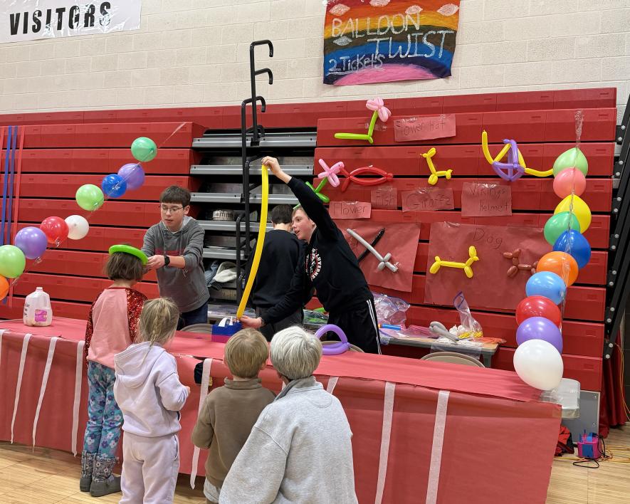 Eighth-graders Andrew Wieneke (left), Oliver Carbonneau (back turned) and Emmett Woodley make balloon figures for waiting children at the Music Boosters Winter Carnival Saturday, Jan. 24. Greg Hoogeveen/Rock County Star Herald Photo