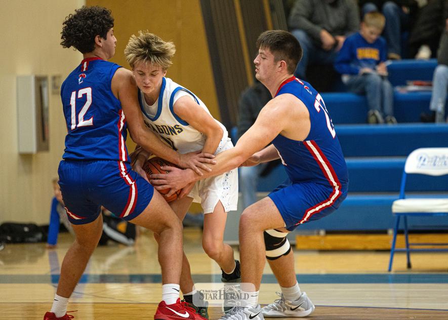 Samantha McGaffee photo/HBCBBB2 H-BC senior EJ Wegener, No. 12, and junior Riggins Rheault, No. 23, double-team an Adrian player from advancing the ball Dec. 4 in Hills. H-BC won the game 78-41 against the Dragons.