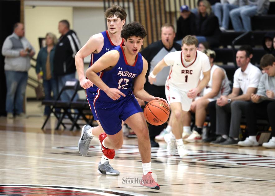 Greg Hoogeveen photo/HBCBBB2 Senior EJ Wegener moves the ball up the court against Red Rock Central followed by senior Jamin Metzger in a fast break to the hoop Feb. 28. H-BC won the game 68-29 .
