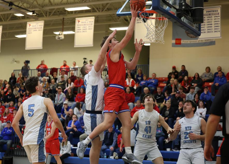 Greg Hoogeveen photo/HBCBBB3 Patriots senior Jamin Metzger taps in a basket after throwing the ball at the backboard and grabbing the rebound in the air for two points. Metzger had 14 points and 10 rebounds at home against the Knights. H-BC won the game 70-46 Friday, Feb. 13.