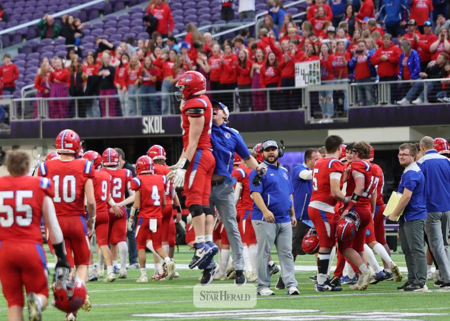 Greg Hoogeveen photo/HBCFB3 Patriots coach Dylan Gehrke and senior Wyett Shimp jump side-by-side after beating Fertile-Beltrami 40-13 in the 9-player state semifinal game Thursday, Nov. 13, at US Bank Stadium. Shimp had three tackles, two sacks and one interception in the game.