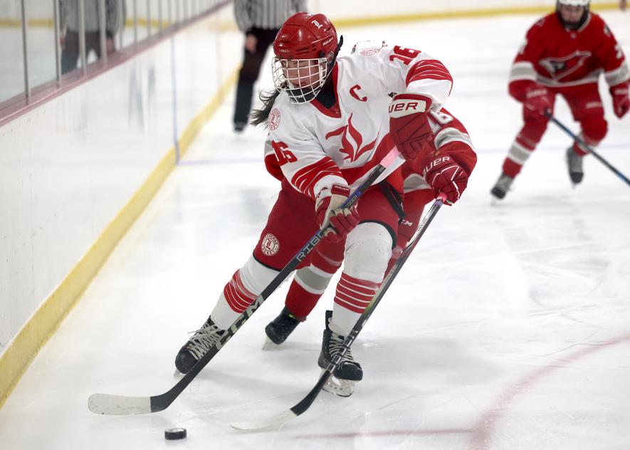 Greg Hoogeveen photo/LHS GHOC2 LHS junior Macie Edstrom holds off a Willmar skater behind her as she works the puck along the boards on home ice Friday, Dec. 12. The Luverne girls’ team won the game 4-1.