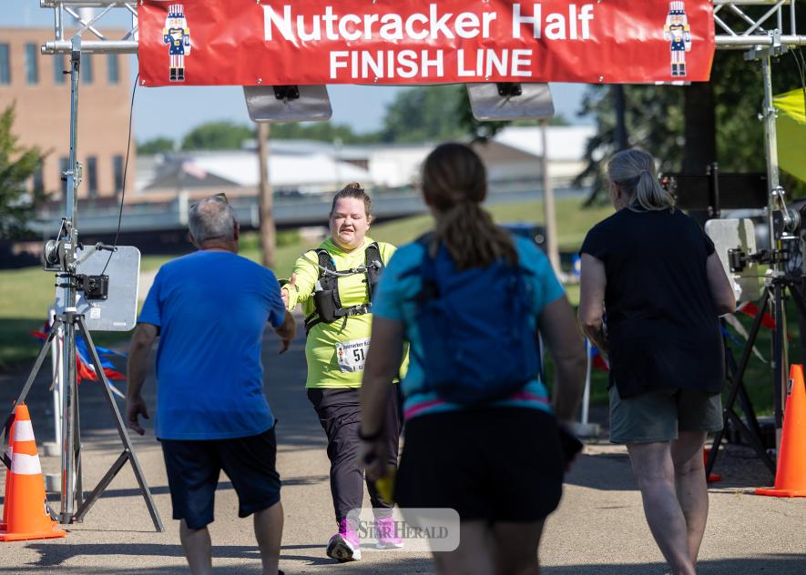 Greg Hoogeveen photo/NCmarathon Shelby Bell of Topeka, Kan., is greeted by Dave Duffy and volunteers after she finished the Nutcracker Half Marathon Walk Saturday, July 11, in Luverne. 