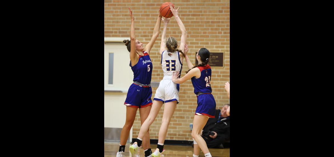 Senior Lanae Elbers (No. 5) and junior Emma Deelstra (No. 23) guard the net against Adrian during their section quarterfinal game Saturday, Feb. 24, in Worthington. The Patriots beat the Dragons 64-61 in the overtime game.