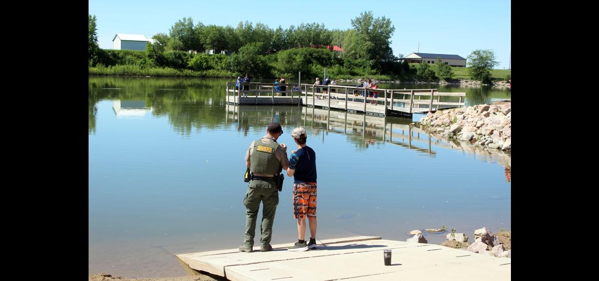 Conservation officer Dustin Roemeling (left) talks with Alarick Stanley about casting a line into The Lake. Mavis Fodness/Rock County Star Herald Photo