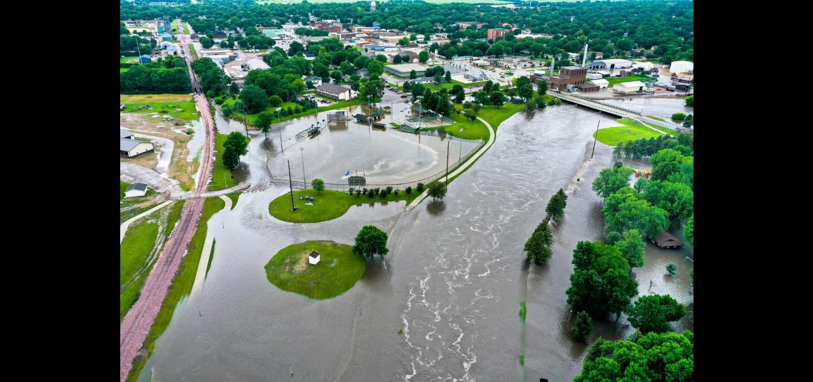 In this drone image facing the city Luverne from the west, the Rock River is seen overflowing its banks Friday, June 21, and spilling into Redbird Field (center) and the Luverne City Park (far right). The river crested Sunday afternoon just under the record set in June 2014. Photo courtesy of Cade Wenningerr