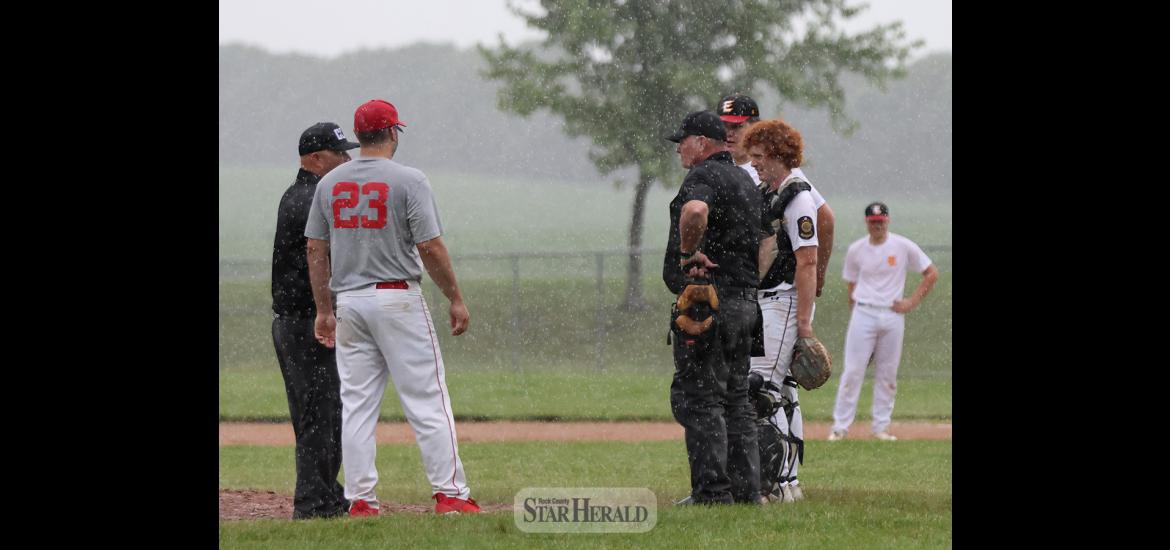 Coaches and umpires discuss weather conditions in Luverne Thursday, June 27. The Senior Legion game between Luverne and Edgerton was called off after one inning due to rain.