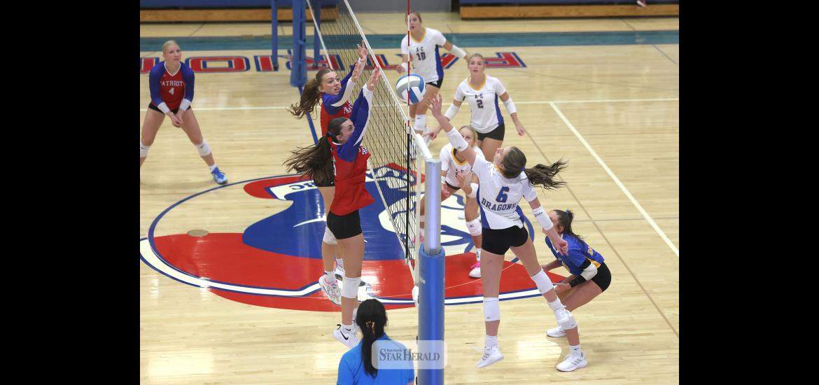 Greg Hoogeveen photo/1008HBCAEVB2 A-E junior Jordan Kruger reaches for a ball at the net as H-BC players junior Aspyn Bartels and senior Ava Steinhoff jump to block any shot over the net. The Adrian-Ellsworth Dragons beat the Hills-Beaver Creek Patriots 3-0 in the match at Hills.