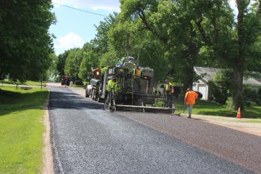 After several weather and equipment delays, a crew from Dakota Seal of Sioux Falls on May 22 applies a slurry mixture to the residential streets on the east side of Hills. The surface is a quick-setting emulsion, which acts like a leveling agent over cracks and potholes. It replaces the more typical seal-coating process. In a matter of days, Dakota Seal finished the project. Mavis Fodness/Rock County Star Herald Photo