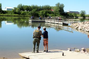 Conservation officer Dustin Roemeling (left) talks with Alarick Stanley about casting a line into The Lake. Mavis Fodness/Rock County Star Herald Photo
