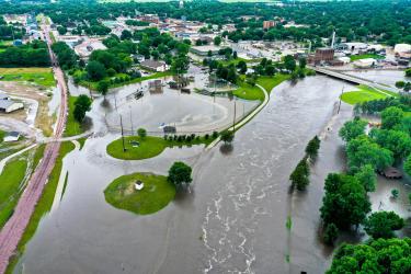 In this drone image facing the city Luverne from the west, the Rock River is seen overflowing its banks Friday, June 21, and spilling into Redbird Field (center) and the Luverne City Park (far right). The river crested Sunday afternoon just under the record set in June 2014. Photo courtesy of Cade Wenningerr