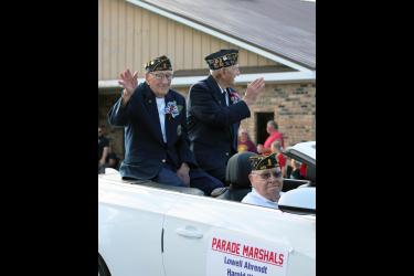 Parade marshals (from left) Russell Wenzel, Lowell Ahrendt and Harold Kindt wave to the crowds lining Main Street in Hardwick Saturday night for the annual Jubilee Days parade. All three served in the Korean War and became members of the Hardwick American Legion Post No. 478 when the post was organized in 1957. After their military service, each maintained longtime connections to the Hardwick community. Mavis Fodness/Rock County Star Herald Photo