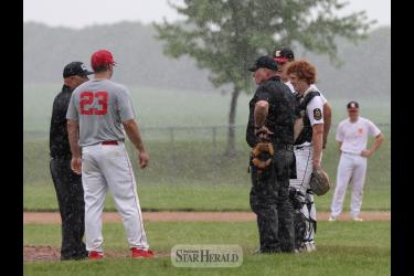 Coaches and umpires discuss weather conditions in Luverne Thursday, June 27. The Senior Legion game between Luverne and Edgerton was called off after one inning due to rain.