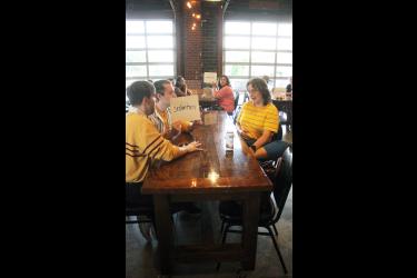 The team of Andrew Prekker (left), Evan Prekker and Anita Marden decide the spelling of “sedentary” during the Adult Spelling Bee July 30 sponsored by the Rock County Library at Take 16 in Luverne. The team of Leah Ayom, Amber Decker and Amelia Brake is in the background. Mavis Fodness/Rock County Star Herald Photo