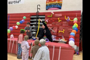 Eighth-graders Andrew Wieneke (left), Oliver Carbonneau (back turned) and Emmett Woodley make balloon figures for waiting children at the Music Boosters Winter Carnival Saturday, Jan. 24. Greg Hoogeveen/Rock County Star Herald Photo