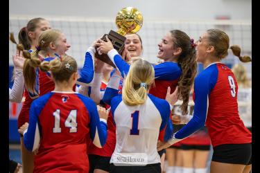 Greg Hoogeveen photo/0924HBCVB1 H-BC volleyball team members cheer upon receiving the “Queens of the Court” trophy at the end of a 3-0 win against Edgerton Public in Hills Thursday, Sept. 17.