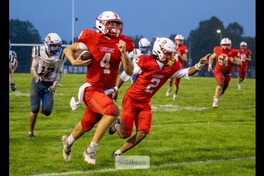 Greg Hoogeveen photo/0924LHSFB1 LHS senior Ben Hartquist runs along the sideline on his way to the end zone flanked by senior Jaymyn McLaughlin Friday, Sept. 18, in Luverne. LHS beat Windom 47-3 in the game.