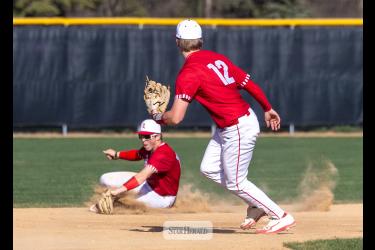Greg Hoogeveen photo/LHSBB2 Luverne shortstop senior Blake Sauer slides to stop a line drive against Windom Tuesday, April 21, in Luverne. Senior Josh Hansen, No. 12, runs to cover third base in the play. LHS fell 11-2 to Windom in the game.