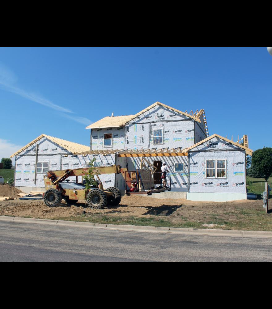 On Monday Jake Guy (driving the telehandler) and Matthew Sterrett (on scaffolding), along with Joe Guy (inside), complete roofing work at the home they are building on Manfred Drive. The three are all Luverne High School graduates.
