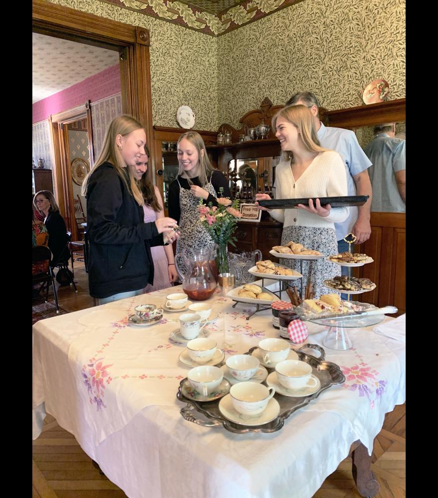Joy Taubert (center, holding tray) talks with fellow H-BC seniors (from left) Olivia Susie, Madison Gengler and Avril Susie along with her dad Brian (hidden) at Friday morning’s tea event organized through Taubert’s business, Sip of Joy.